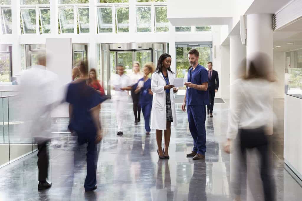 Staff In Busy Lobby Area Of Modern Hospital