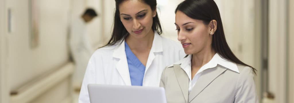 Two female professionals working on a laptop