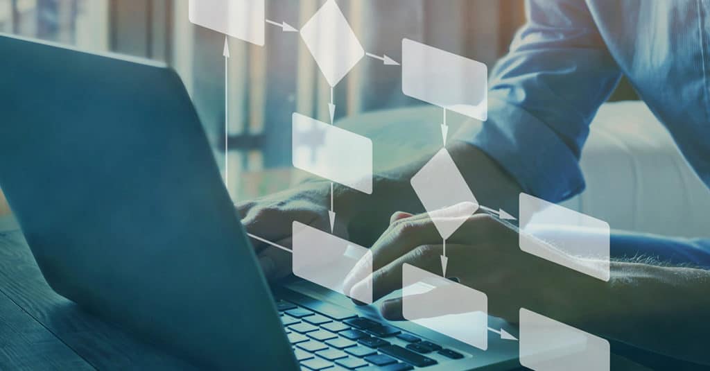 Professional working on a laptop with a visual overlay of process and automation graphs