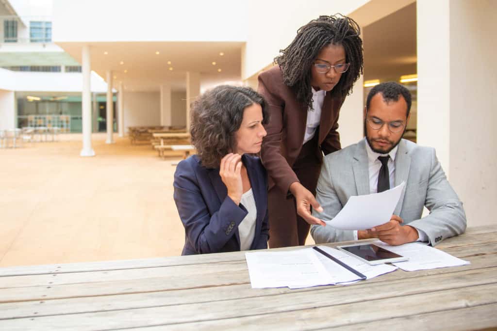 Business team of three studying documents